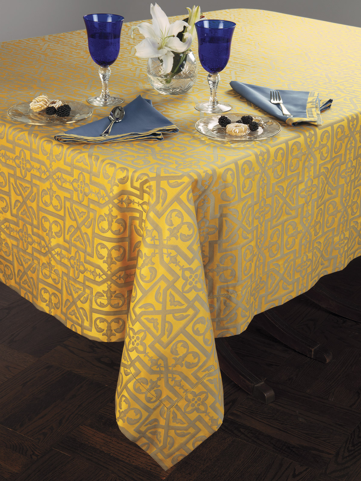 This Italian-made table set is a sumptuous Gold damask design with hemstitching