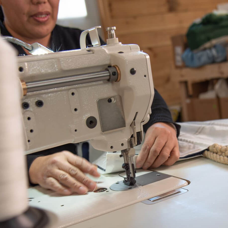 A person hand-sewing a Sea Bag