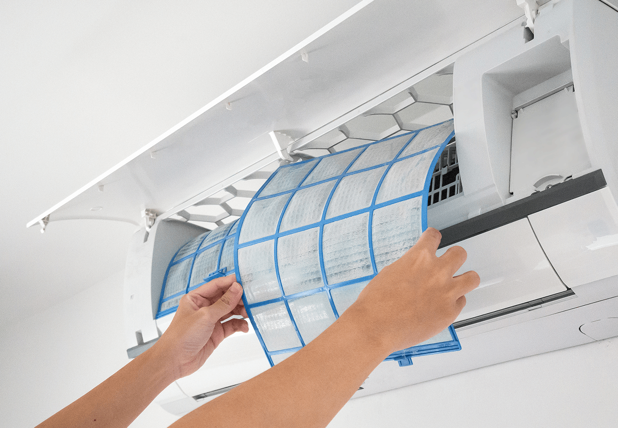 A person taking out a filter from an AC unit