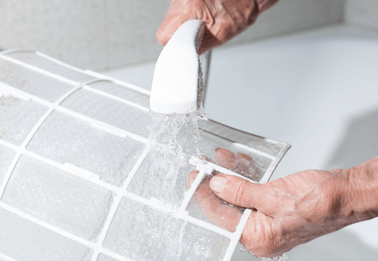 A person washing an HVAC filter
