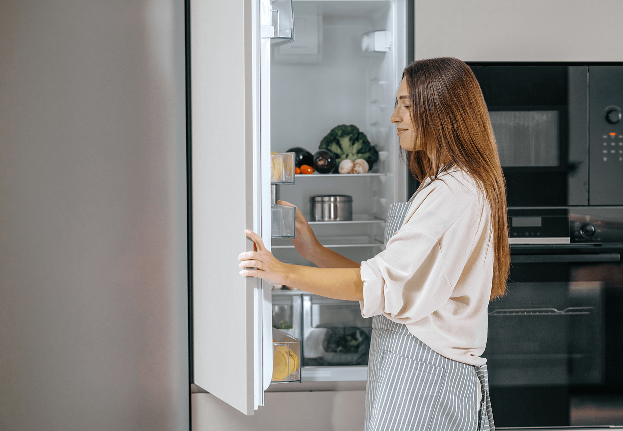 A woman opening a refrigerator
