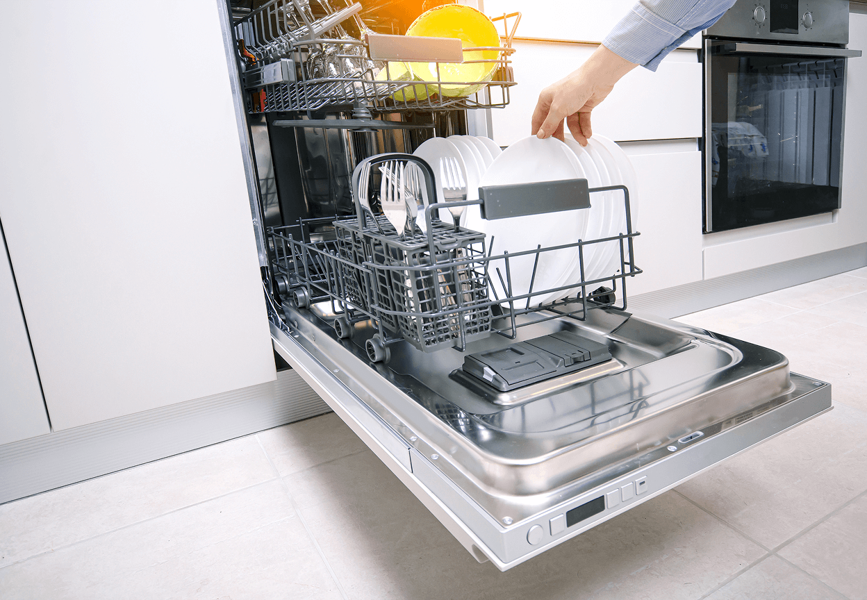 A person grabbing a white dish from a stainless steel dishwasher