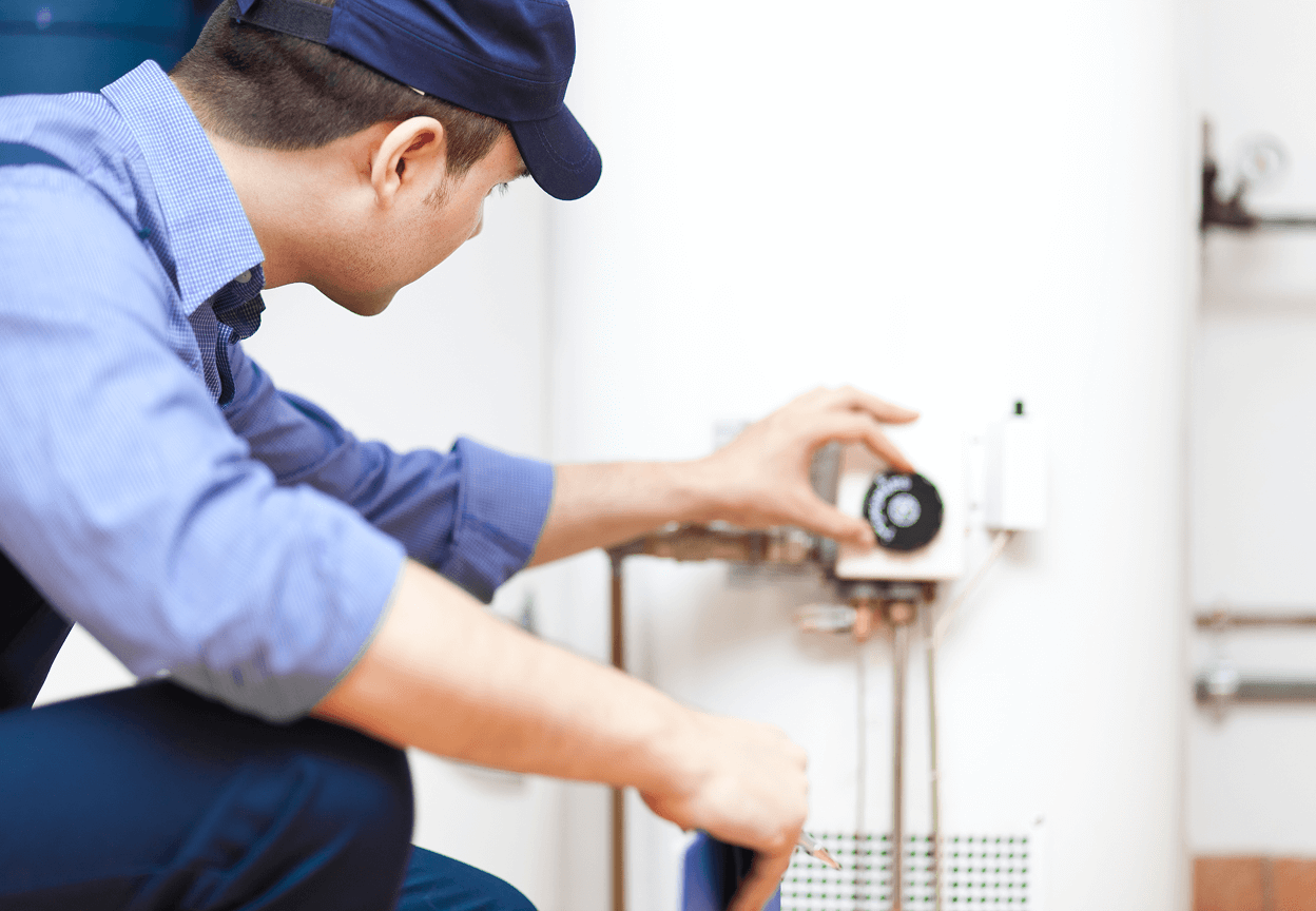 A Sears Technician adjusting a dial on a furnace