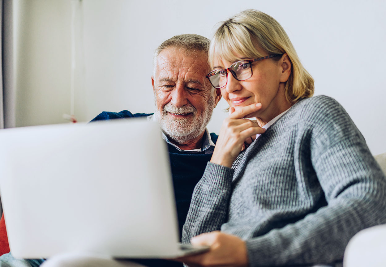 A man and woman look over home warranty options on their laptop