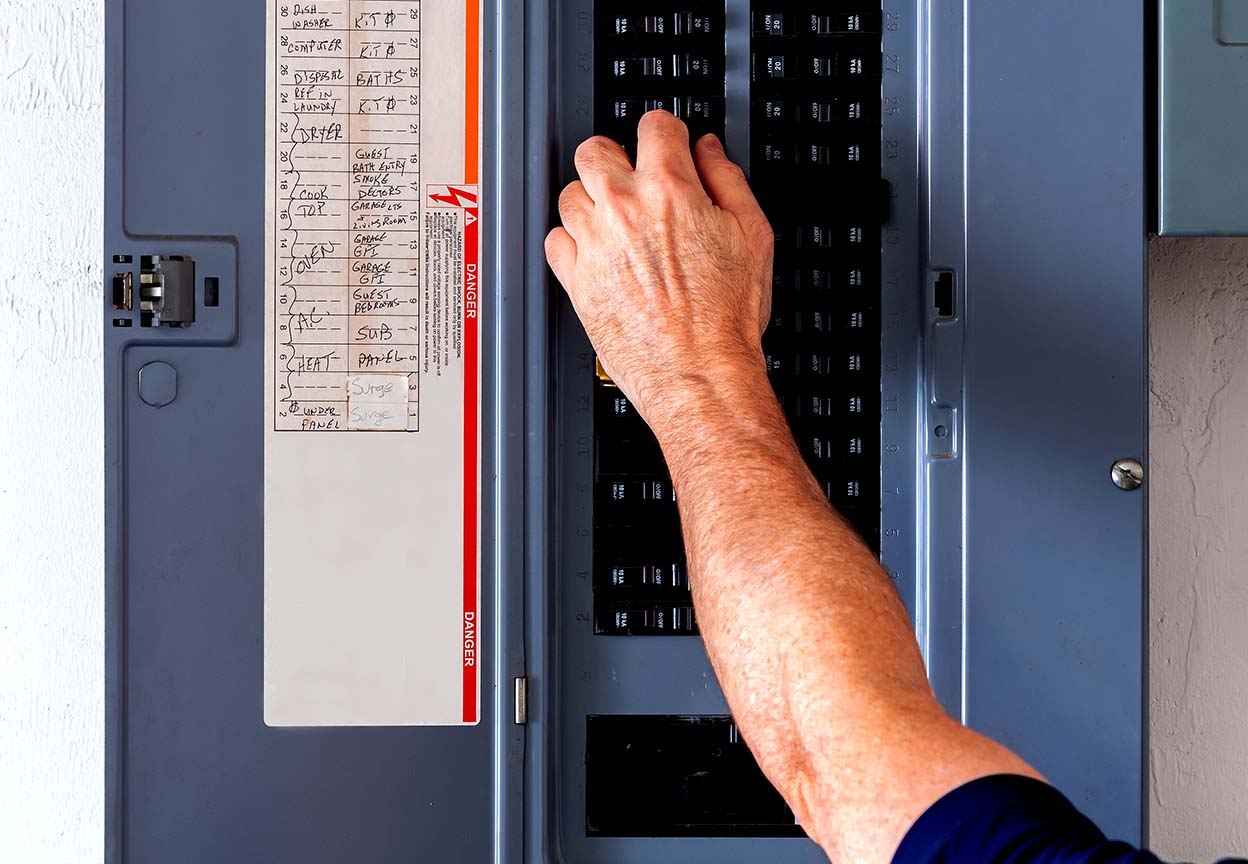 Hand resetting a circuit breaker inside an electrical panel