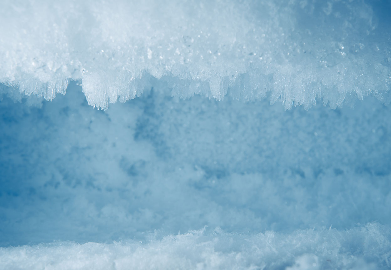 Close-up view of thick frost crystals and icy buildup covering the inside of a freezer