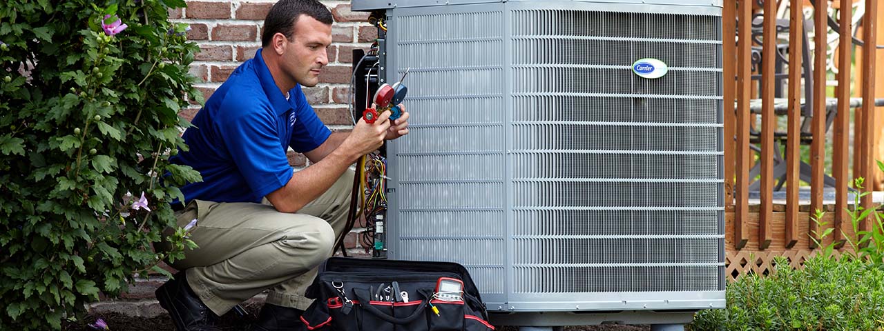 technician looking at a set of gauges near an A/C condenser outside of a customer's home