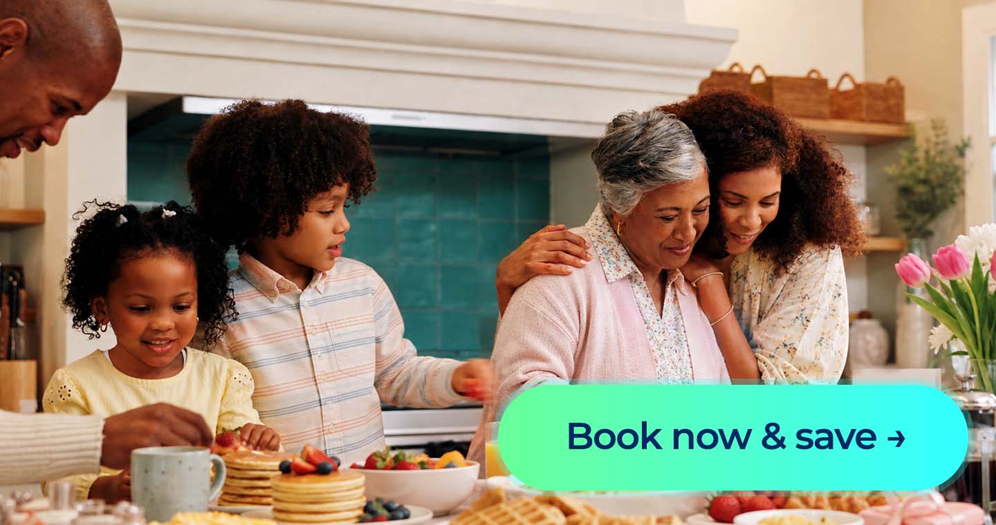 Family gathers around a Mother’s Day brunch table with pancakes, fruit and flowers, alongside a “Book now and save” button.