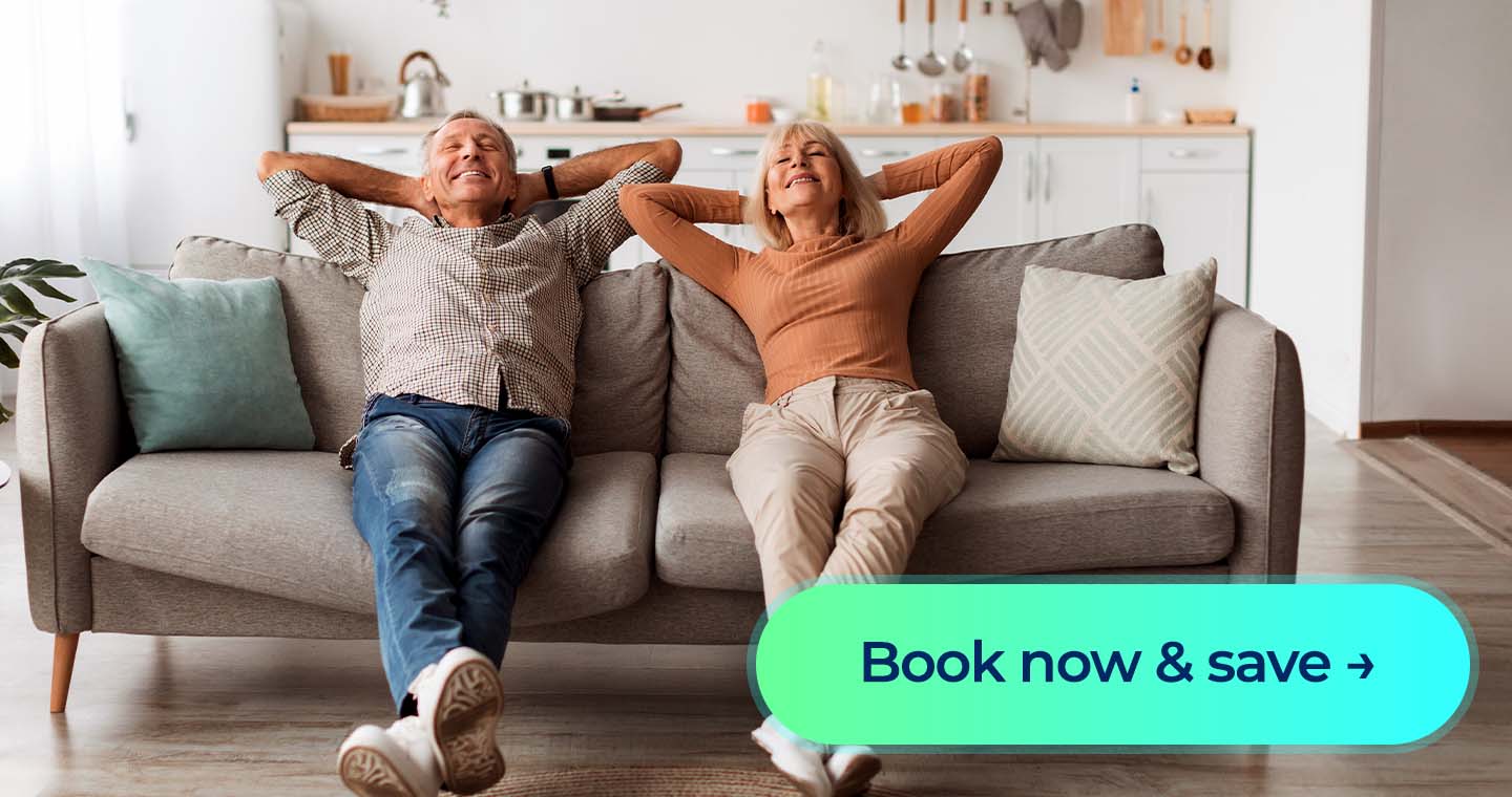 A couple relaxing on a couch in a bright home with a “Book now & save” button.