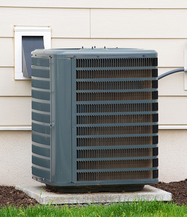 Outdoor A/C condenser unit sitting beside a home.