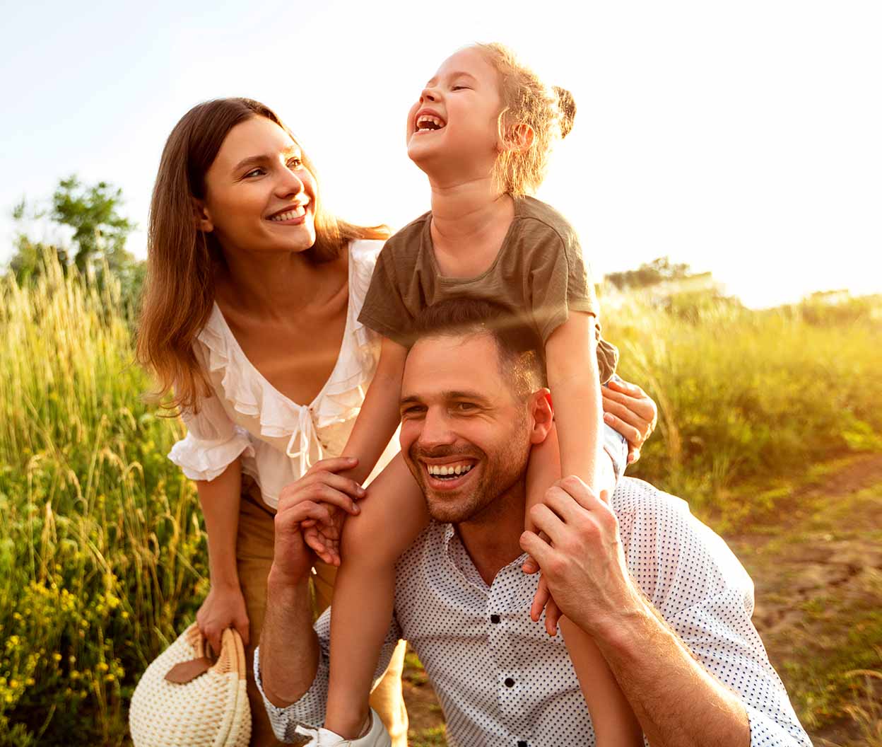 Family enjoying a sunny outdoor walk together in a grassy field