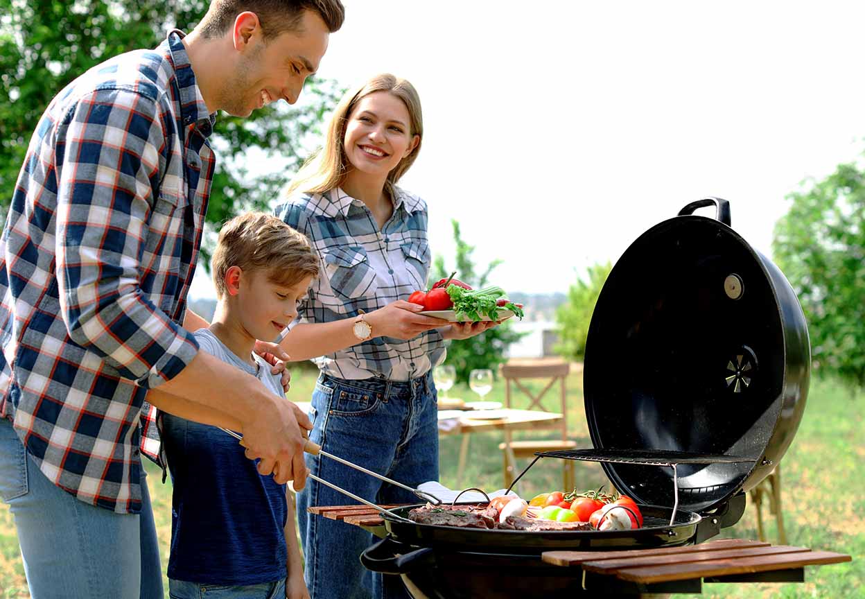 Family grilling together outdoors on a sunny day