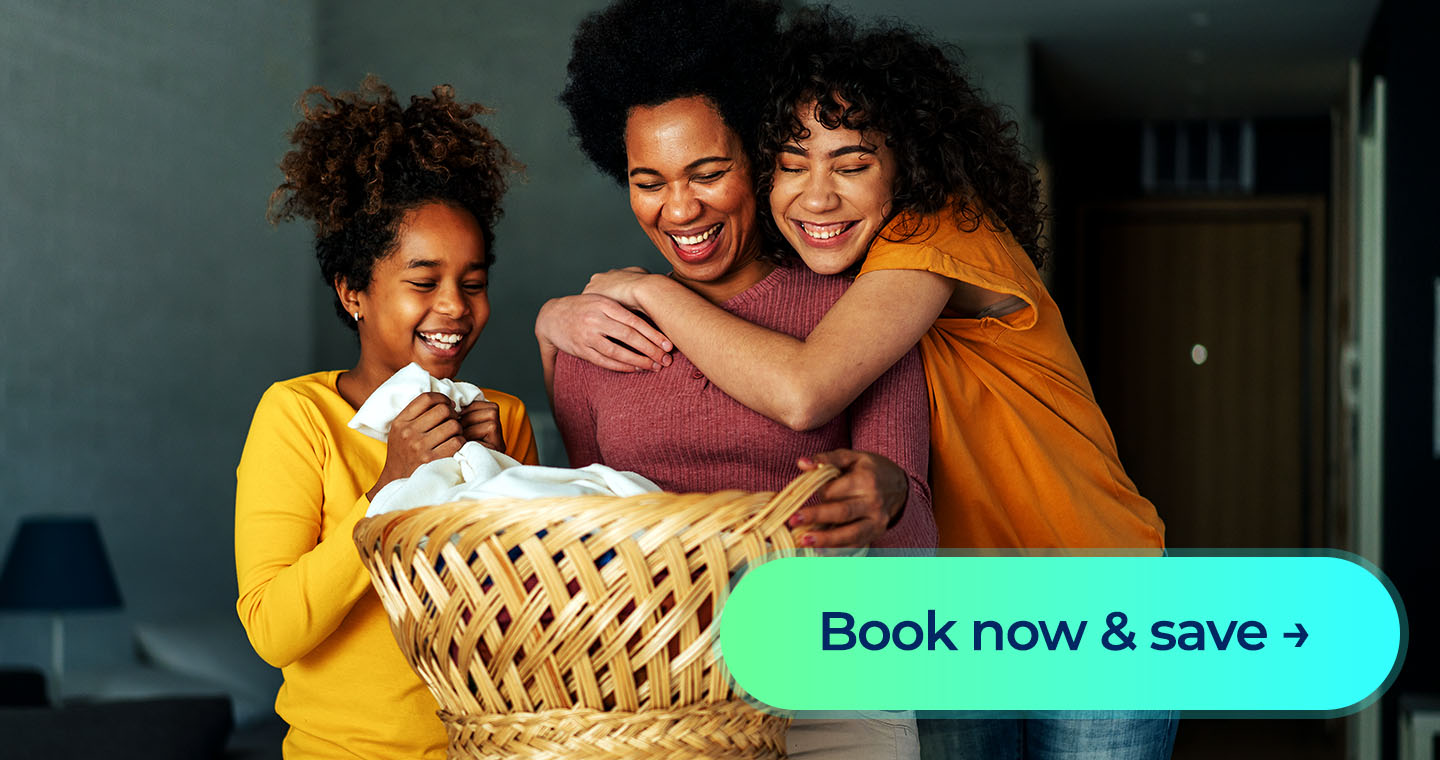 A woman and two children smile over a laundry basket with a “Book now & save” button.