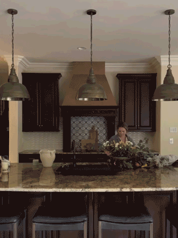 Woman arranging flowers in kitchen