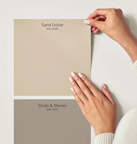Pair of hands applying peel and stick Sand Dollar and Sticks & Stones swatchs.