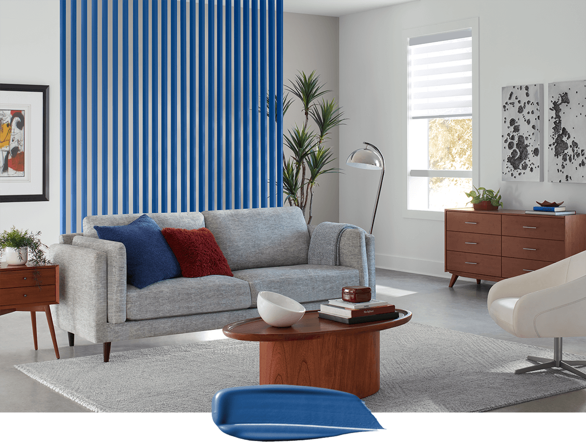 Color swipe overlapping photo of living room painted in Winsome Grey with accents painted in Frank Blue.