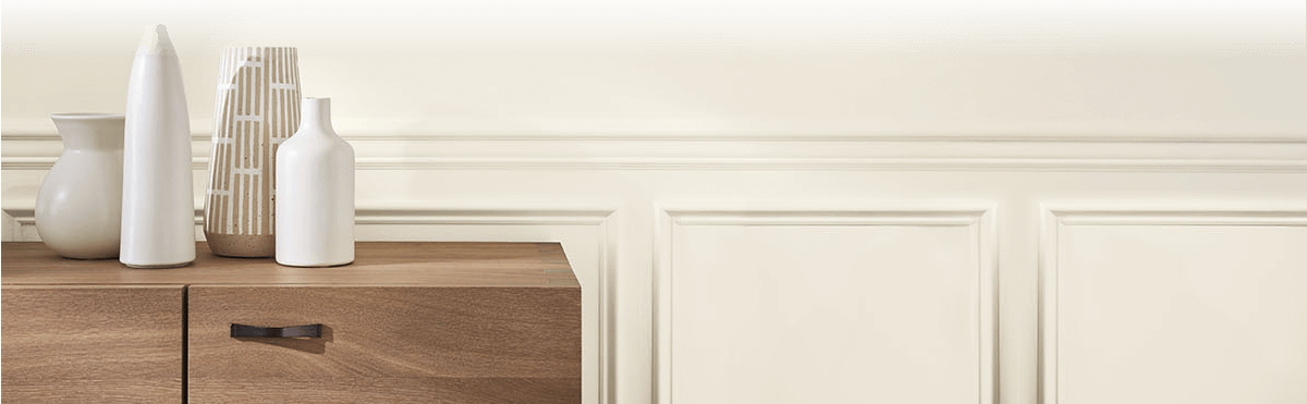Side board cabinet, with various white vases, against a wall coated in Sherwin-Williams paint.