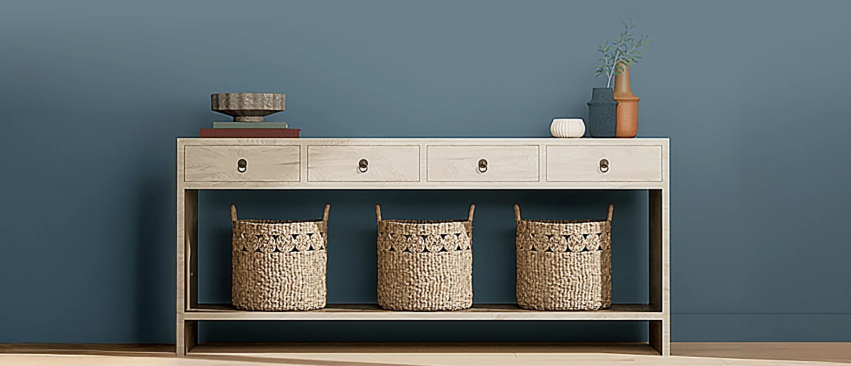 Console table, with baskets and tabletop home decor, in front of wall painted in Smoky Blue.