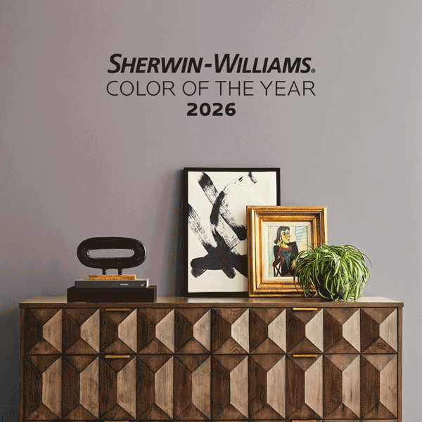 Mid-century style sideboard cabinet, with home decor, plater and frame on top, along wall that is changing color between neutral, blue, green and purple shades.