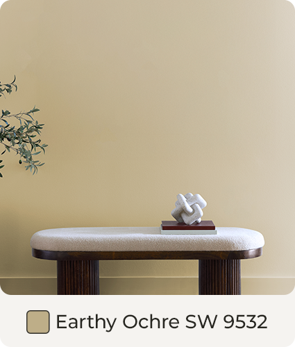 Wall painted in Earthy Ochre behind white padded dark wood bench. Color Swatch. Earthy Ochre SW 9532.