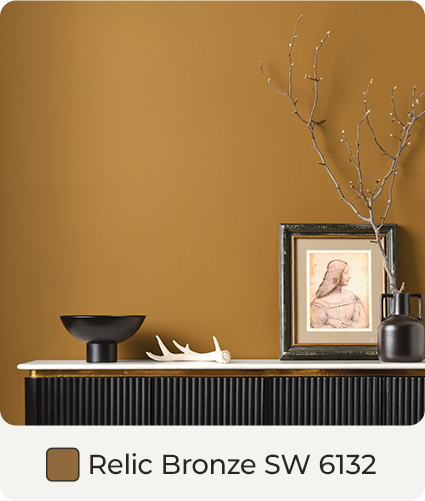 Sideboard cabinet, with frame and tabletop home decor, along wall painted in Relic Bronze. Color Swatch. Relic Bronze SW 6132.