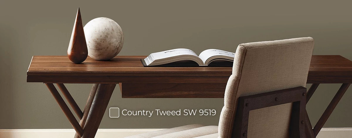 Home decor and open book on mid-century modern desk with chair in room painted in Country Tweed.
