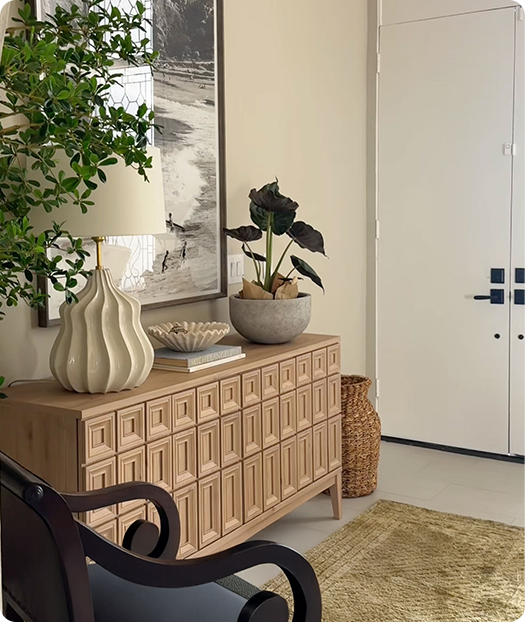 Room painted in Mushroom and decorated in neutrals with brown chair, beige sideboard, lamp, and plant.
