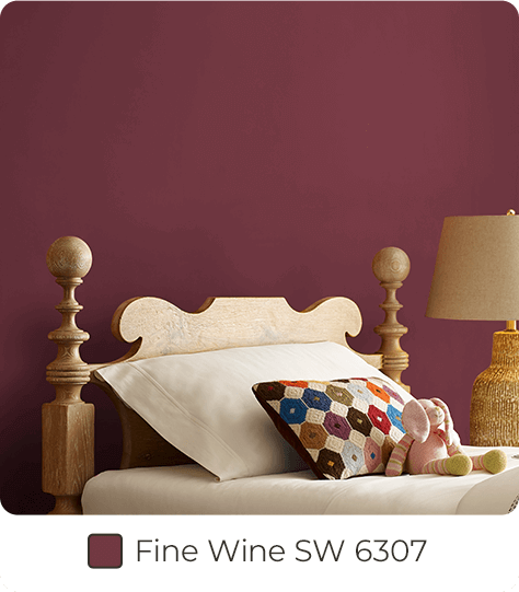 Closeup of traditional bed in bedroom painted in Fine Wine SW6307.