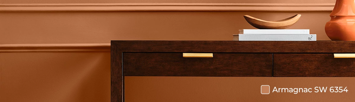Console table with planter and home decor in front of wall painted in Armagnac SW 6354.