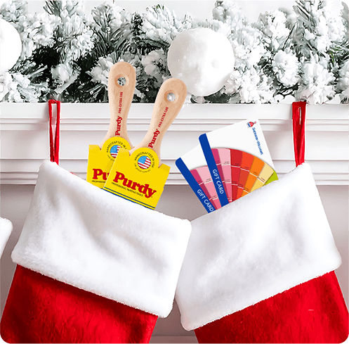 2 red stockings hanging on a white traditional mantle, stuffed with Purdy brushes and Sherwin-Williams gift cards.