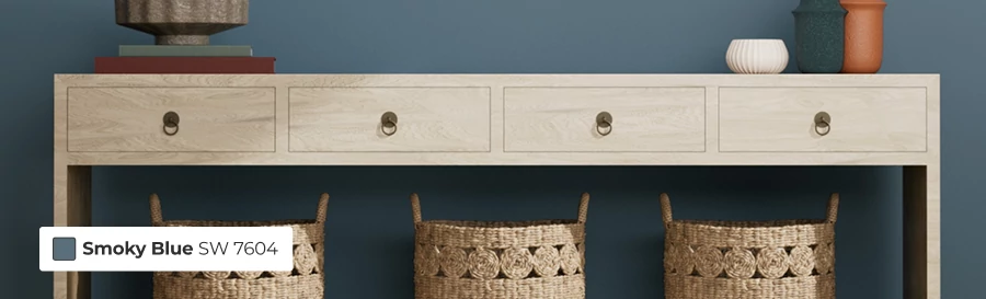 Light wood console table with home decor on top and wicker baskets underneath.