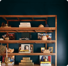 Open wood bookself in room painted in Dark Night.