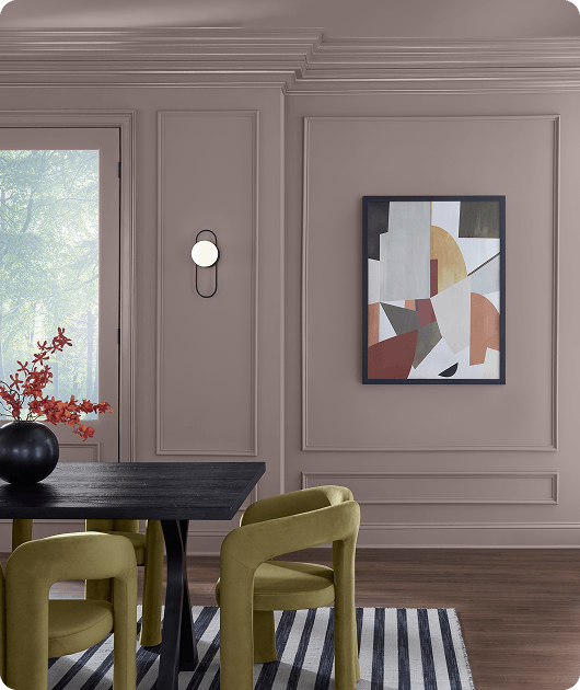 Chinchilla painted paneled wall in dining room with modern green chairs & dark wood dining table.