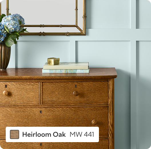 Dresser stained in Heirloom Oak in front of a light blue wood trimmed wall.