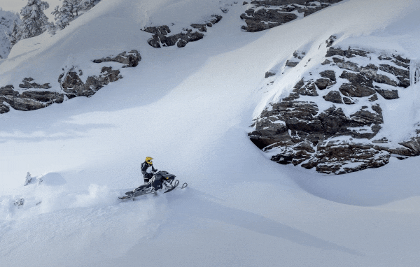 People riding their Ski-Doo in the snow
