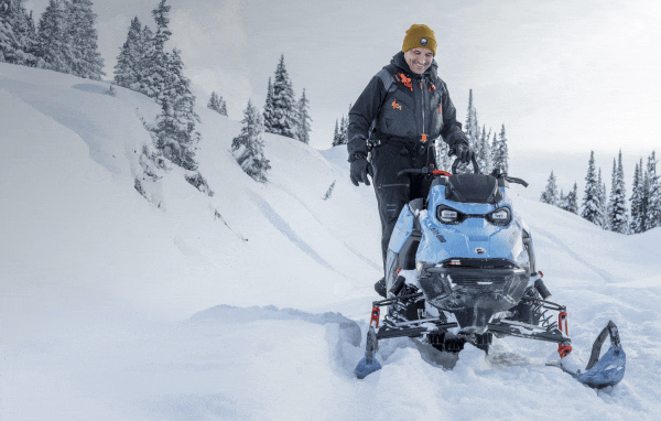 Rider standing next to Ski-Doo sled