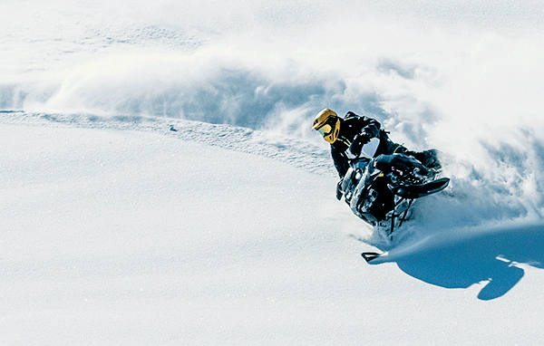 Riders carving through deep snow