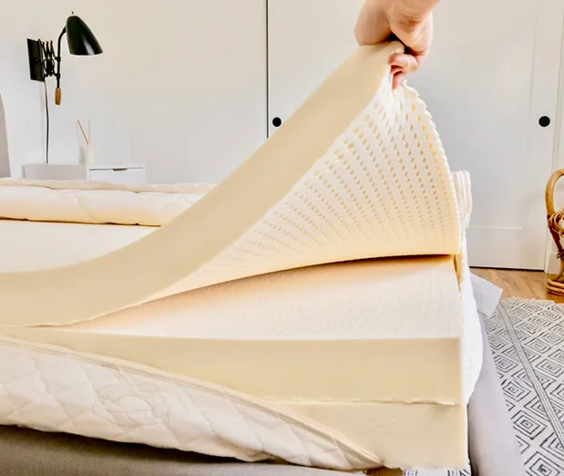 Latex mattress topper on a bed