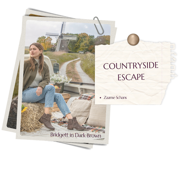 Woman in Bridgett boots in Dark Brown, sitting outdoors with windmills in Zaanse Schans countryside.