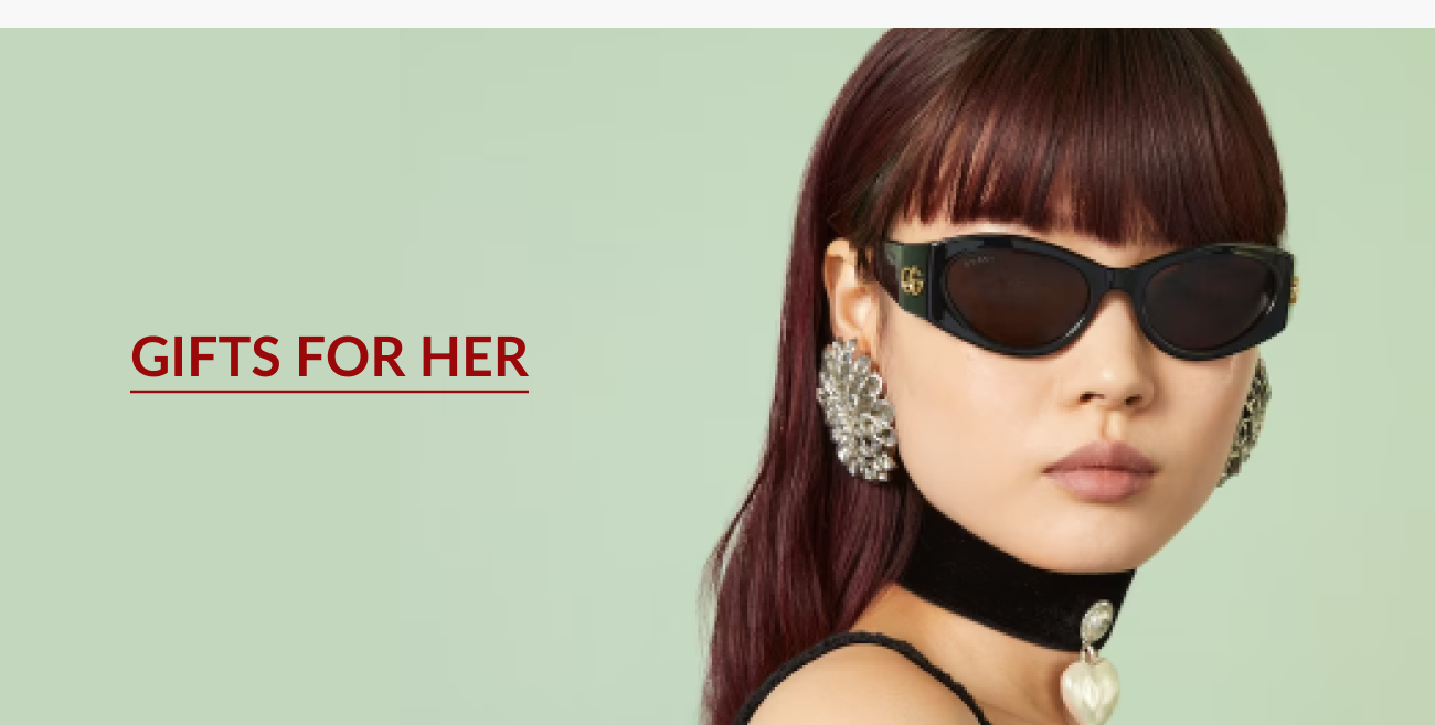 Gifts for her section featuring a model wearing black designer sunglasses against a green background.