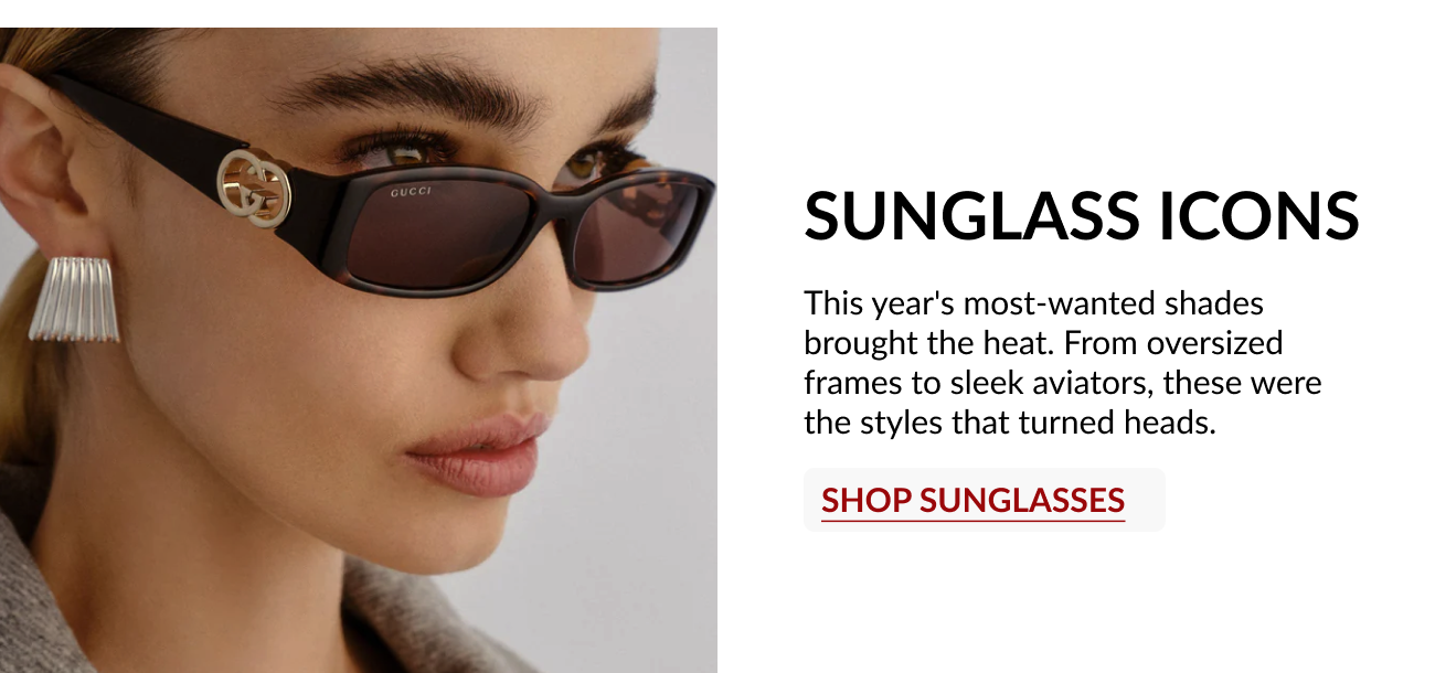 Model wearing black designer sunglasses with sleek rectangular frames and gold logo detail.