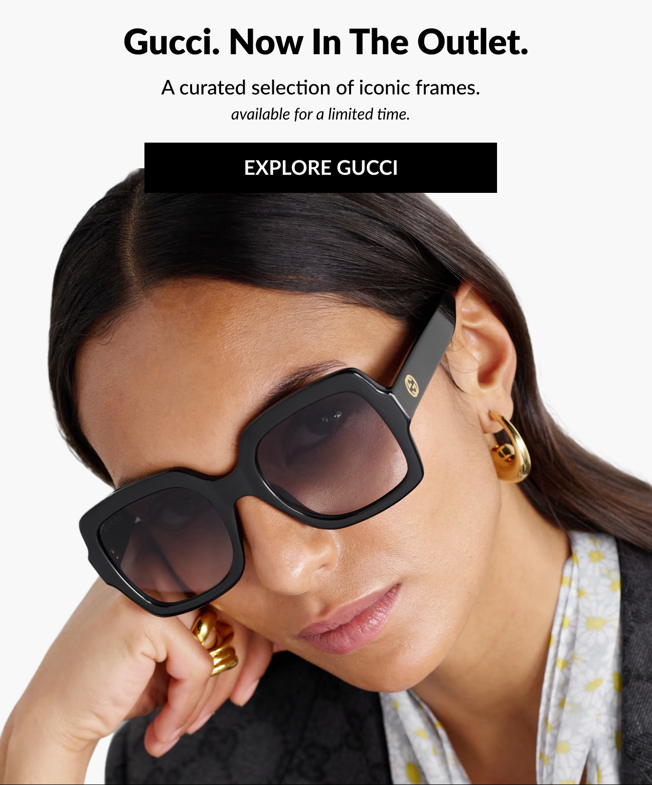 Header section reading, “Gucci. Now In The Outlet.” with subtext “A curated selection of iconic frames, available for a limited time,” and a black “Explore Gucci” call-to-action button over an image of a model wearing oversized black Gucci sunglasses.