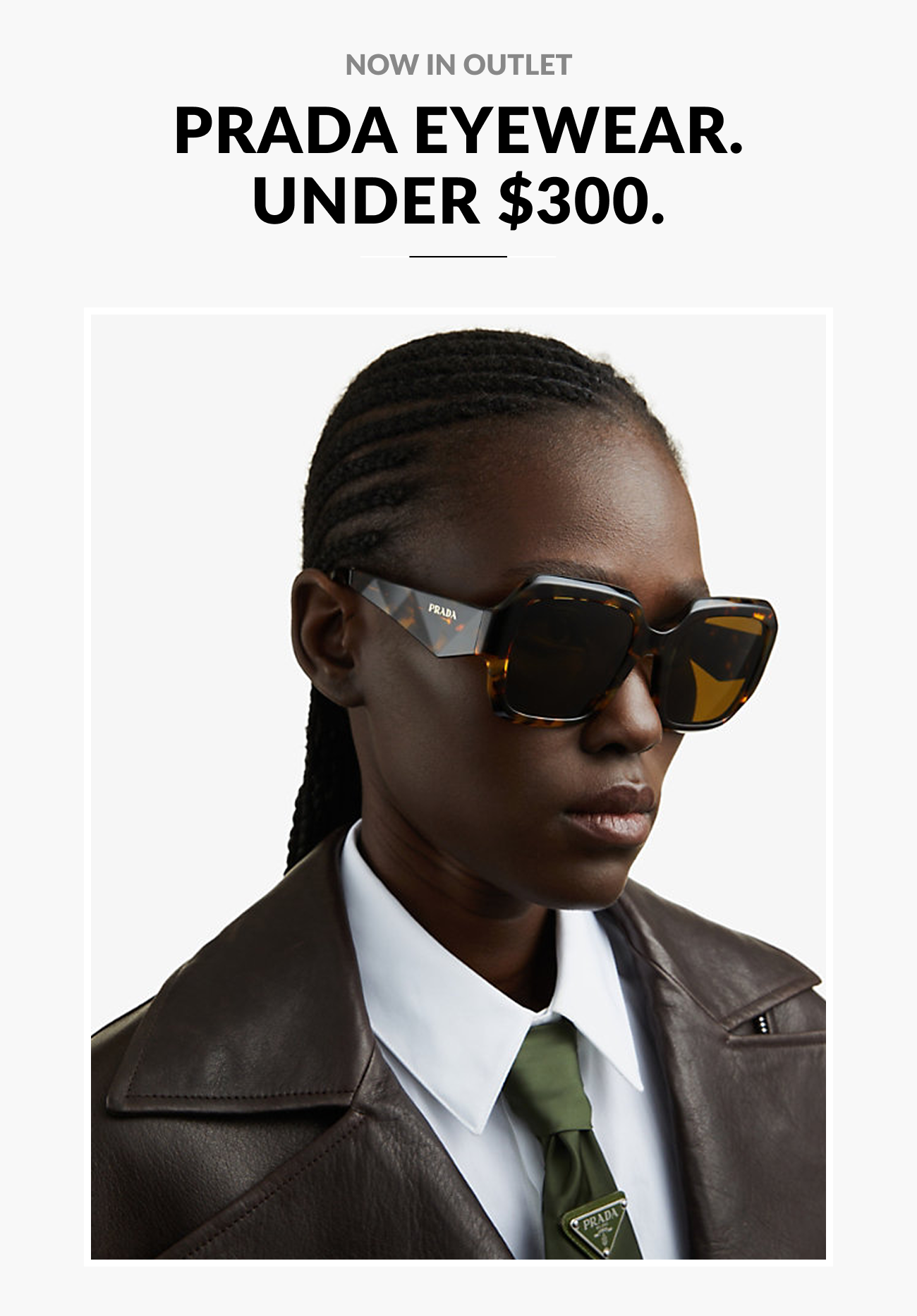 Text reading “Now in Outlet: Prada Eyewear Under $300” above a model wearing oversized tortoiseshell Prada sunglasses with a structured leather jacket and tie.