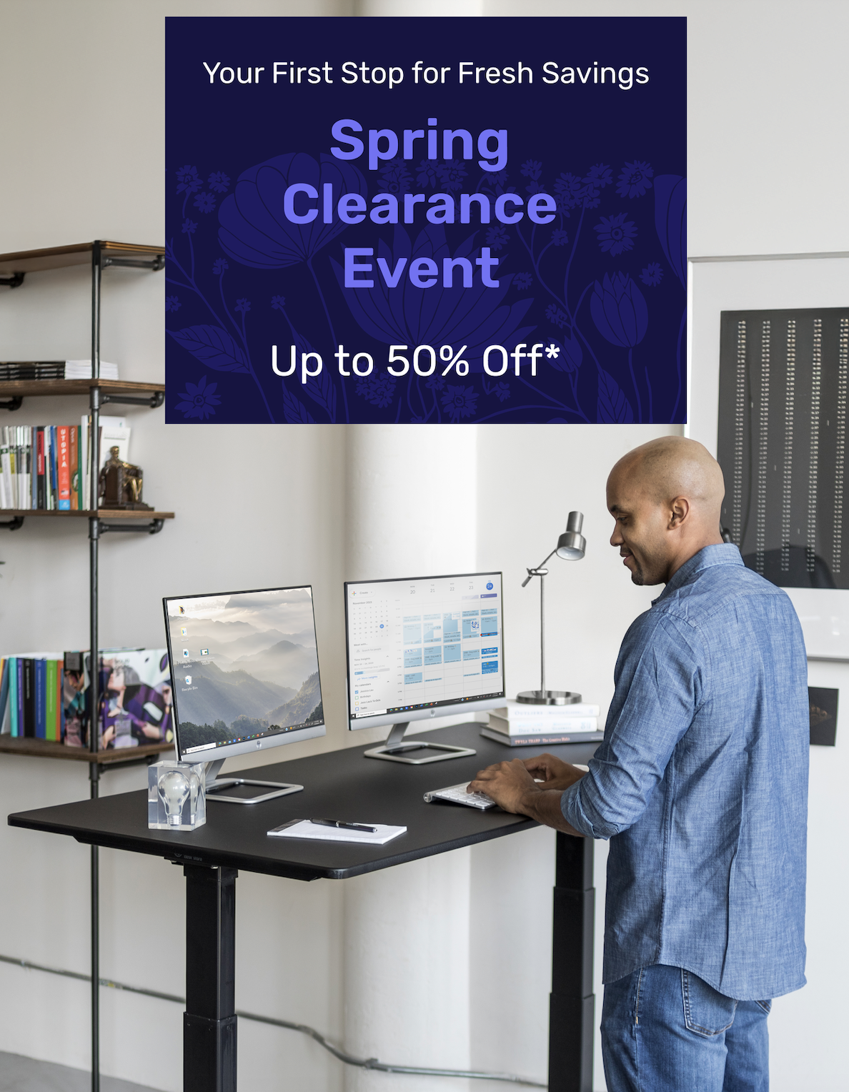 Man working at a standing desk with dual monitors in a modern office. Promotional banner reads: 'Your First Stop for Fresh Savings – Spring Clearance Event – Up to 50% Off*'.