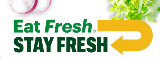 Promotional email for Subway®. The top section shows the headline ‘Eat Fresh®, Stay Fresh’ above a six inch sub on branded wrapping paper, surrounded by lettuce, sliced cucumbers and tomatoes. A caption reads: ‘From fresh-sliced veggies to fresh baked bread, and fresh‑sliced meat—your faves are always fresh‑made.’. A yellow button below says ‘Build Your Sub.’. The next section contains multiple behind‑the‑scenes images of food prep stations, fresh sliced vegetables, sliced meats, and Subway®sandwich assembly. A green headline reads: ‘Behind the scenes with our Sandwich Artists.’. The bottom section highlights ingredients with callouts pointing to tomatoes, bread, and meats on a fully assembled sub, with text describing tomatoes picked at peak ripeness, bread baked daily, and a selection of freshly sliced meat. Overall image promotes freshness and ingredient quality.