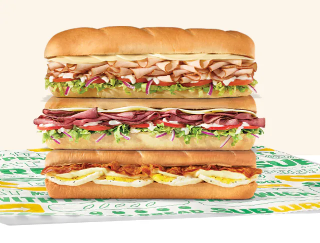 Promotional Subway® email showing an in‑restaurant offer for twenty percent off a sub**. A QR code labeled ‘scan’ appears in the center, with images of three subs below. Text notes the deal is available in restaurant only and requires scanning the QR code to redeem.