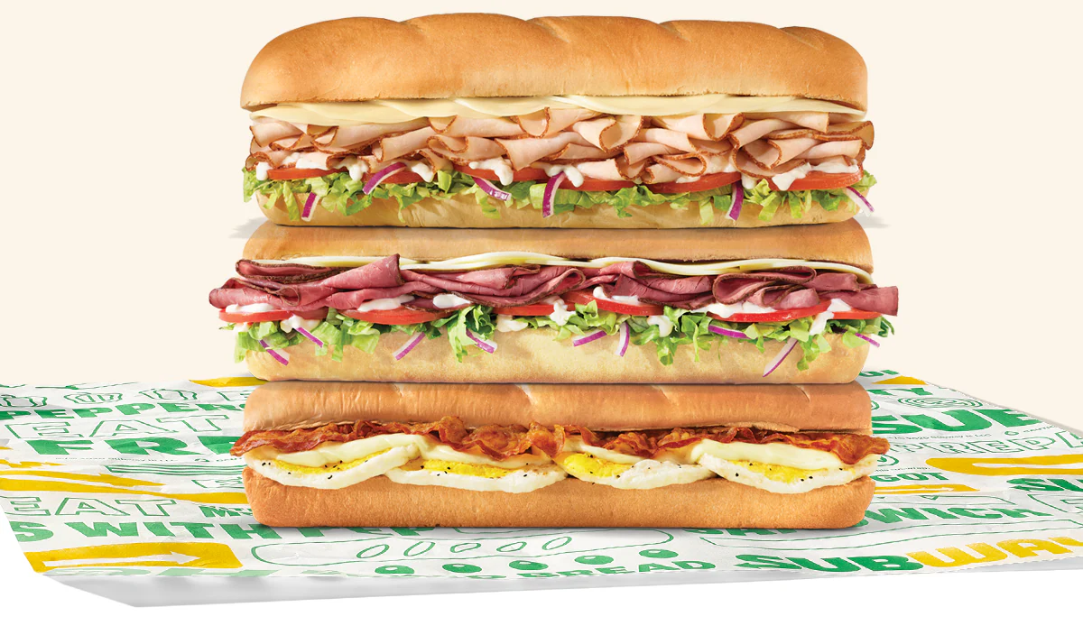 Promotional Subway® email showing an in‑restaurant offer for twenty percent off a sub**. A QR code labeled ‘scan’ appears in the center, with images of three subs below. Text notes the deal is available in restaurant only and requires scanning the QR code to redeem.