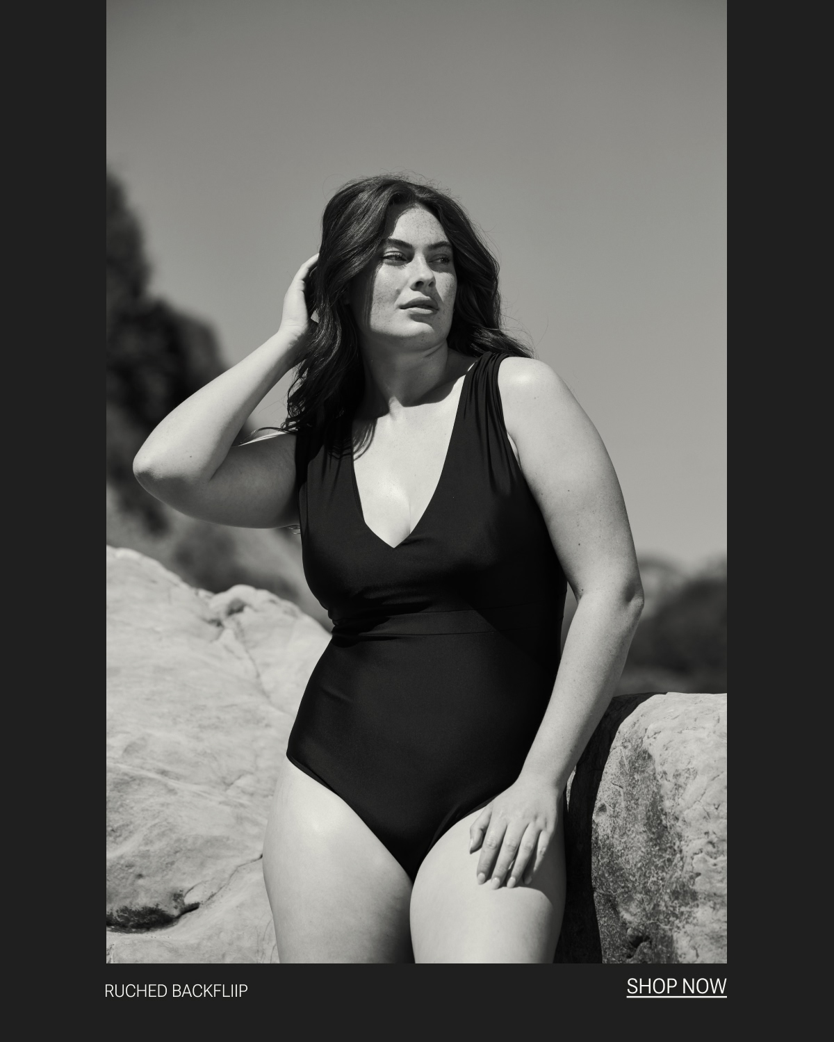 Model in black one piece swimsuit