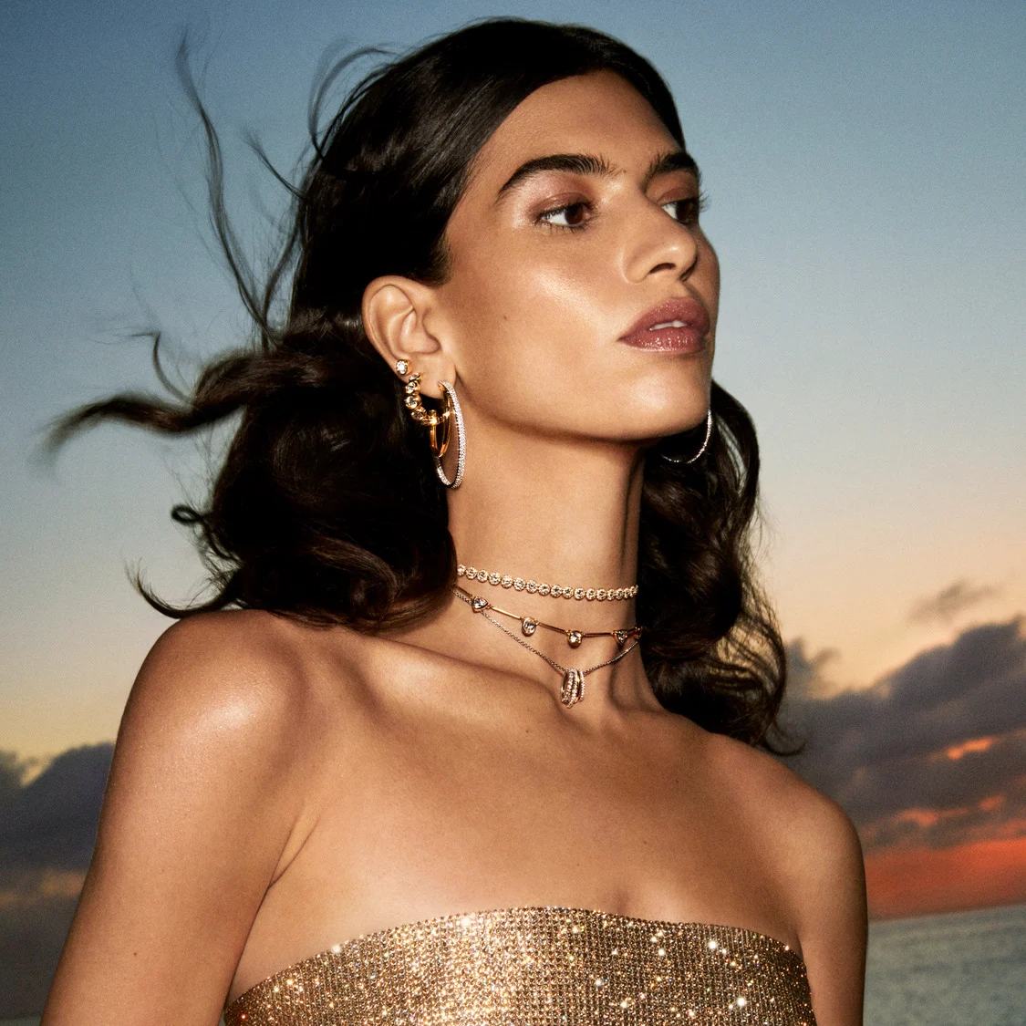 Model wearing gold-tone jewelry
