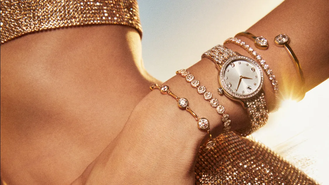 Model wearing gold-tone watch and bracelets